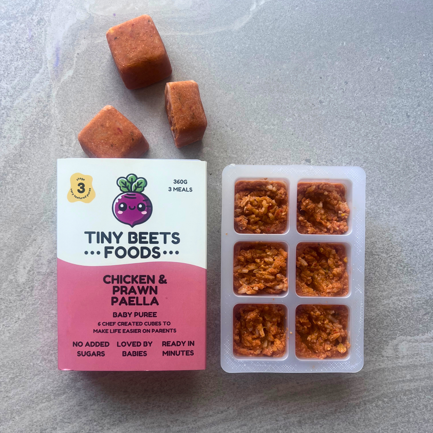 Tiny Beets Foods packaging with frozen cubes on a gray surface